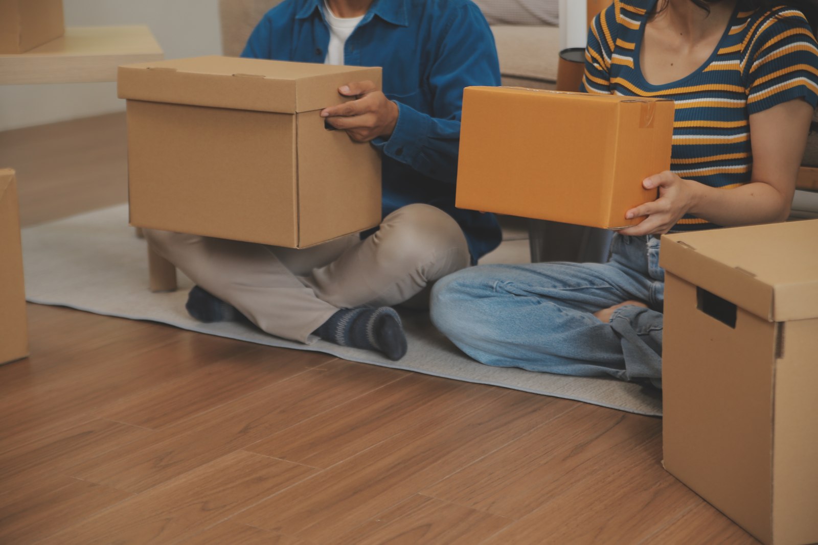 Couple unpacking moving boxes in their new home