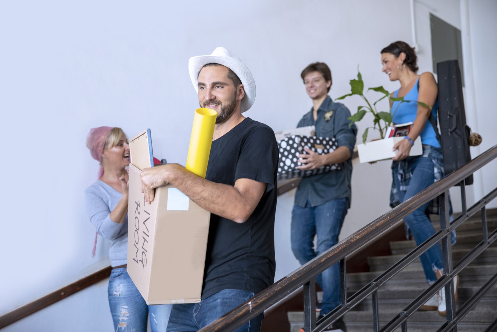 Students carrying boxes while moving to a new apartment