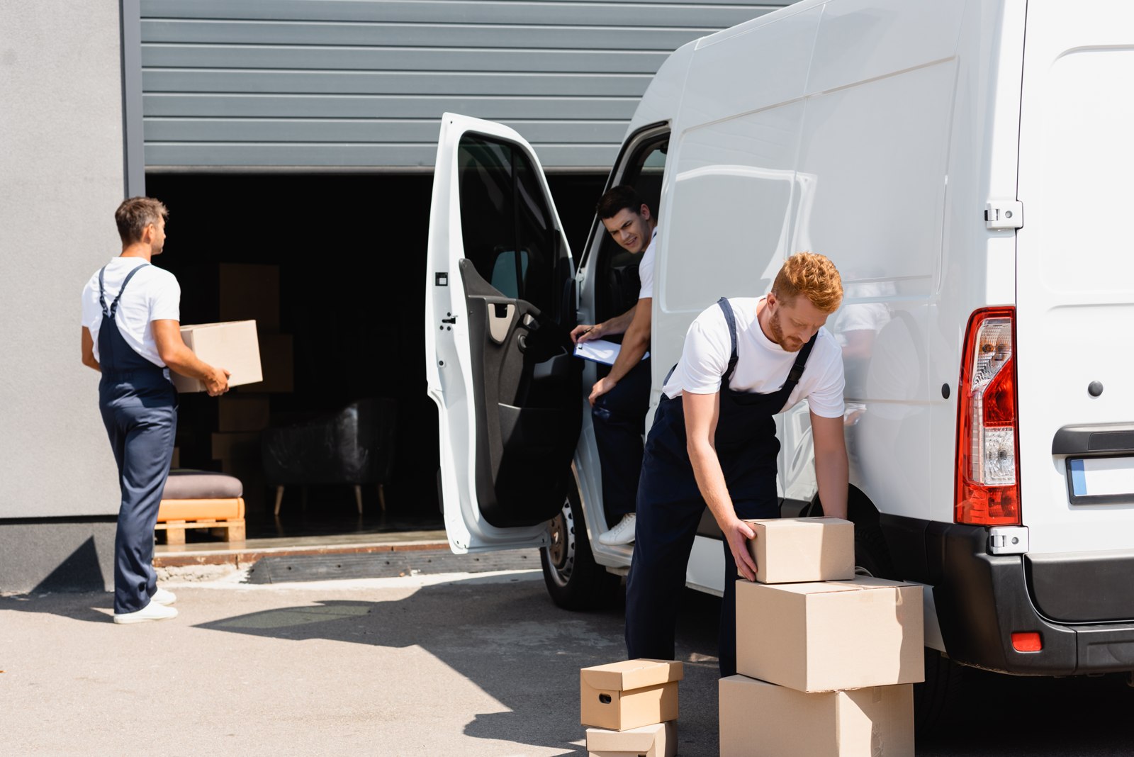 Professional movers loading boxes near a moving truck